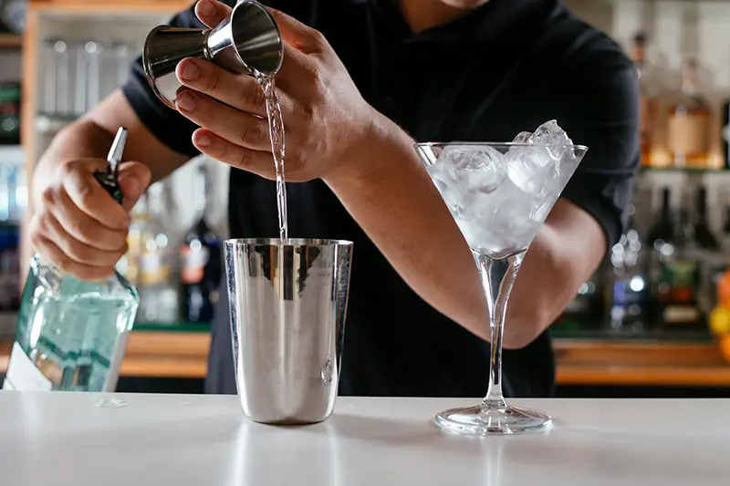 Image of the bartender making drinks or of their hands and cocktails 